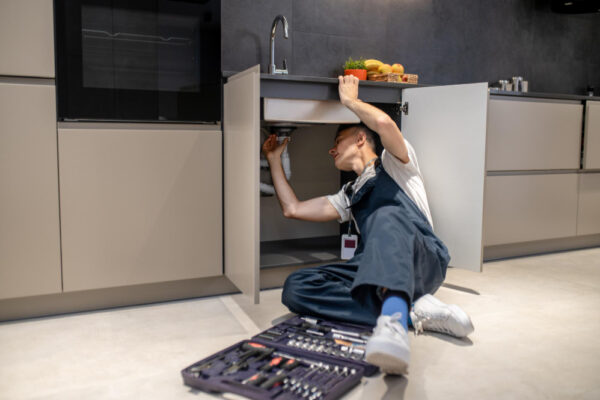 household-repair-middle-aged-man-inspecting-pipe-touching-hand-sink-stylish-modern-kitchen household-repair-middle-aged-man-inspecting-pipe-touching-hand-sink-stylish-modern-kitchen